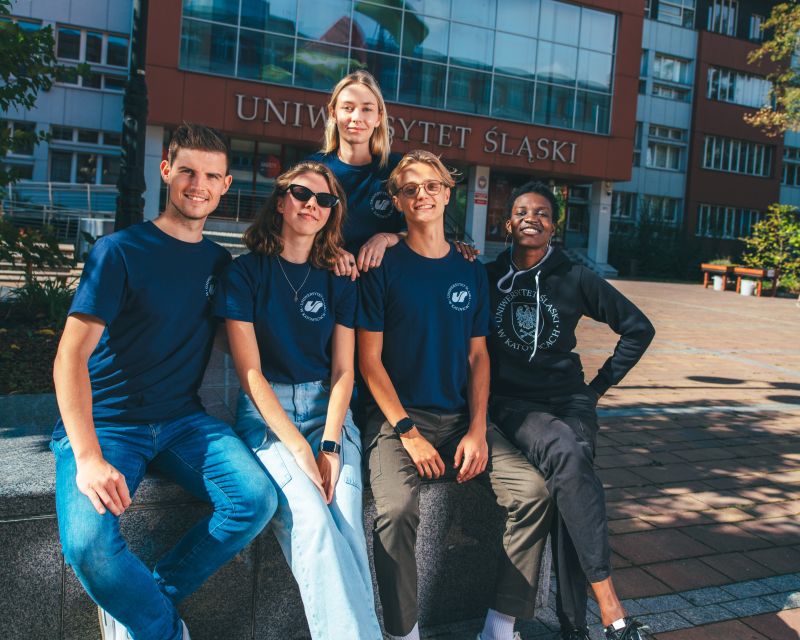 grupa studentów pozująca do zdjęcia pod rektoratem UŚ