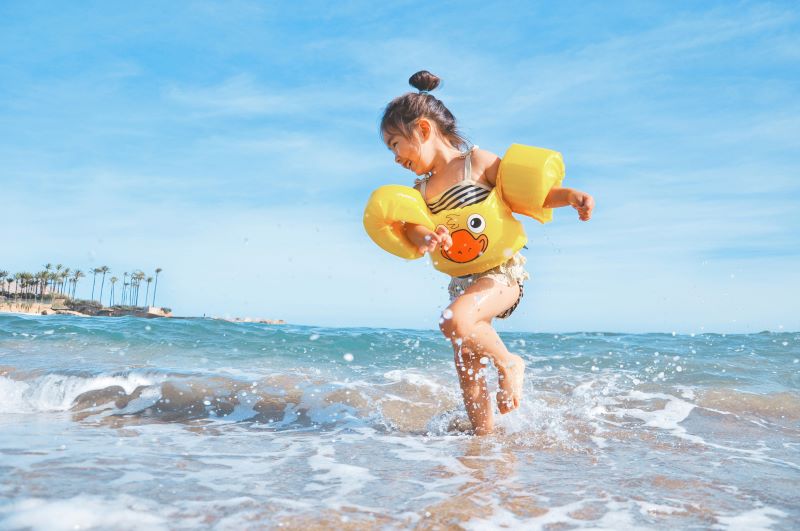 Dziewczyna pluskająca się w wodzie morskiej/A child playing in sea water