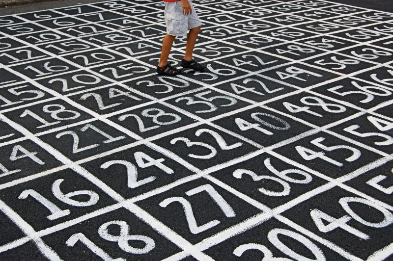 Numery narysowane na ziemi, na dalszym planie widać nogi człowieka