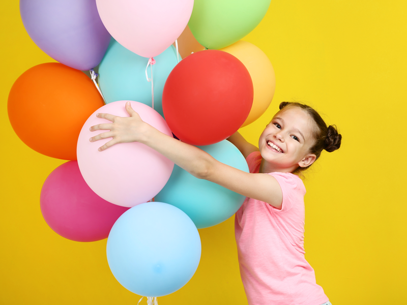 uśmiechnięte dziecko trzyma kolorowe balony / smiling child holding balloons
