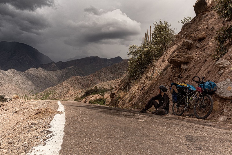 droga, na której siedzi Maria Garus z rowerem, w tle góry