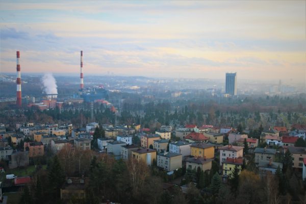 Panorama Sosnowca. Na pierwszym planie domy, w tle znajdują się kominy oraz budynek Wydziału Nauk o Ziemi UŚ