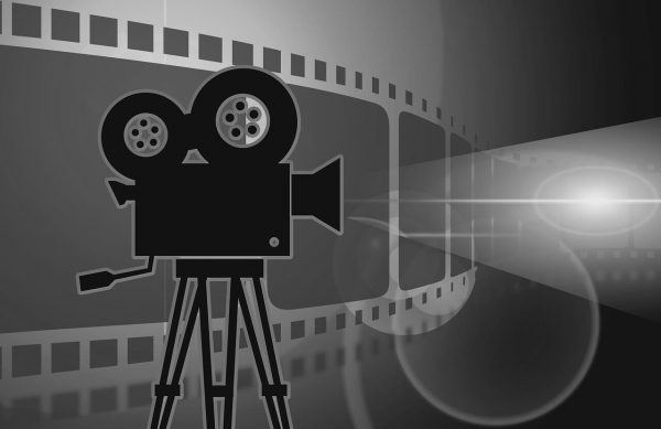Kamera filmowa na tle kliszy fotograficznej