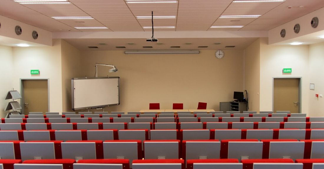 Sala szkoleniowa z siedzeniami i tablicą w tle/Training room with seats and a blackboard in the background