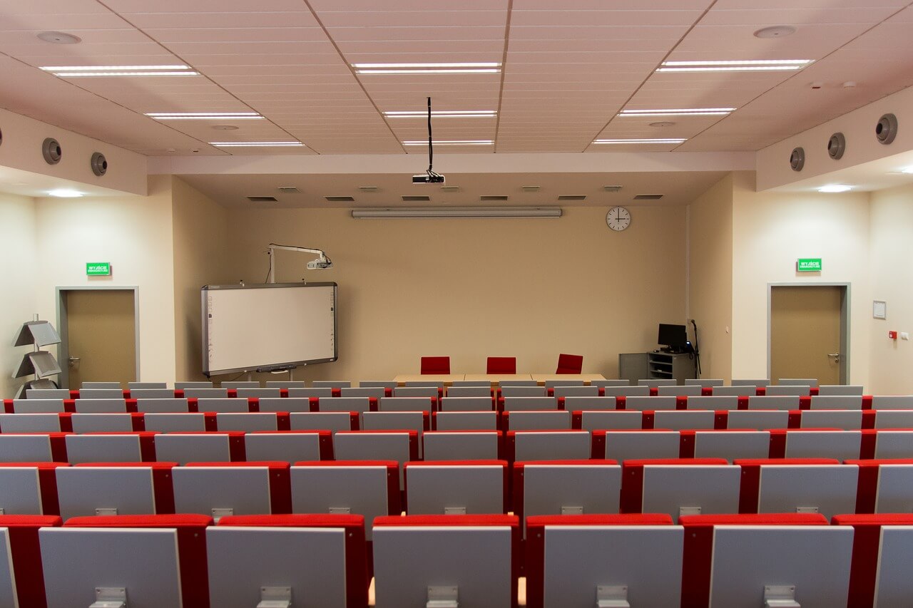 Sala szkoleniowa z siedzeniami i tablicą w tle/Training room with seats and a blackboard in the background