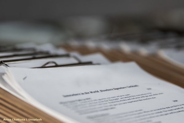 Widok na spięte arkusze papieru z zamazaną treścią