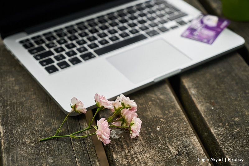 kwiat leżący przed laptopem