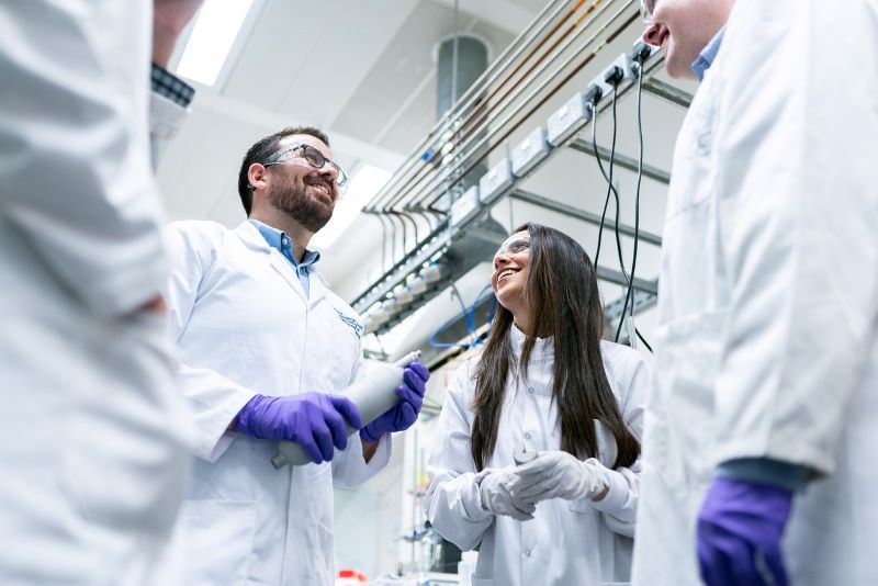 młodzi naukowcy w białych fartuchach i niebieskich rękawiczkach/young scientists in white aprons and blue gloves