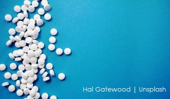 Białe tabletki na niebieskim tle