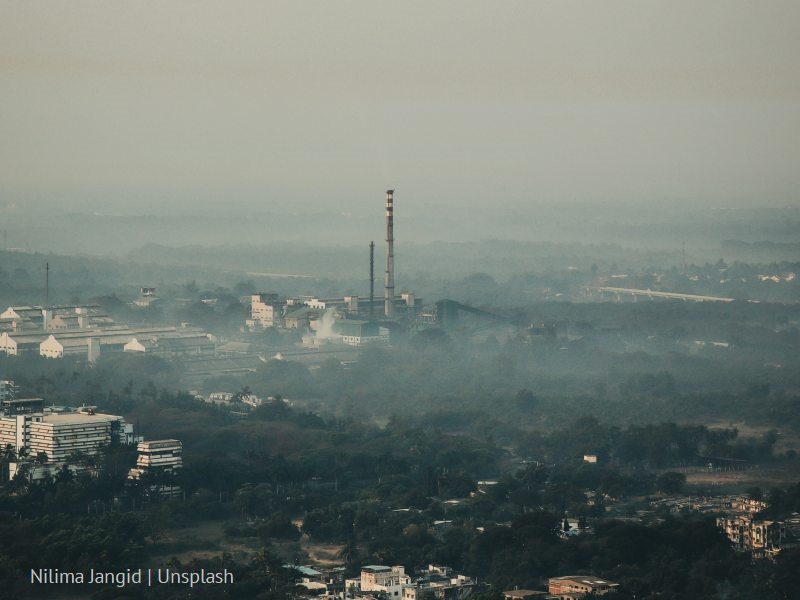 Smog w miejscowości, widoczna fabryka z wysokim kominem/Smog in a city, factory with a tall chimney