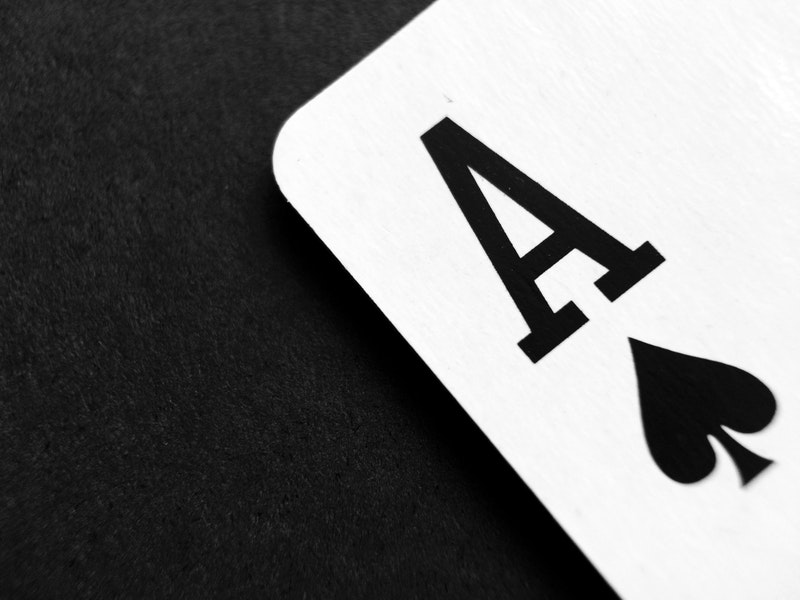 karta asa pik położona na czarnym stole/ace of spades on a black background