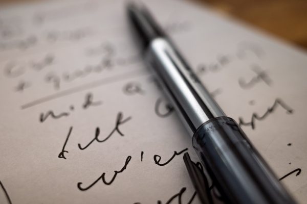 Długopis leżący na zapisanej kartce papieru