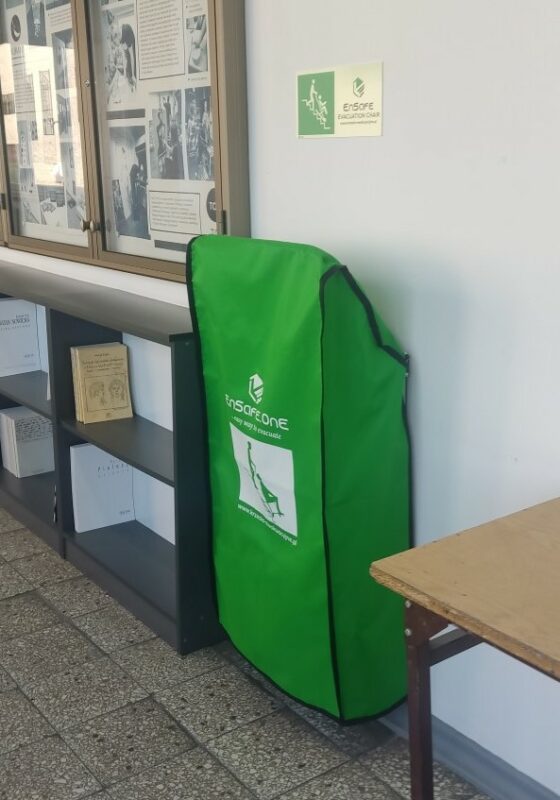 sprzęt w zielony pokrowcu, zamontowany przy ścianie/evacuation chair in a green case mounted on the wall