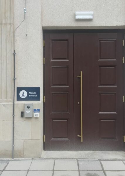 wejście do budynku, po lewej piktogram osoby na wózku i system otwierania drzwi / entrance, on the left: person on a wheelchair sign and a door opening system