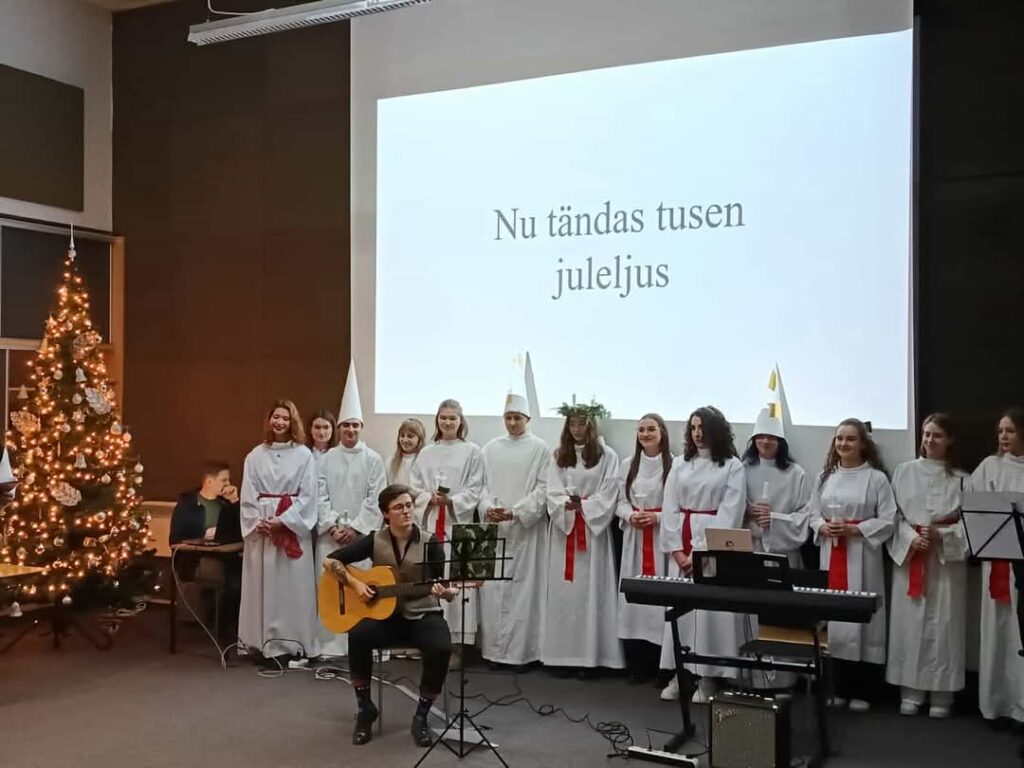 orszak św. Łucji śpiewający kolędy przy akompaniamencie gitary akustycznej