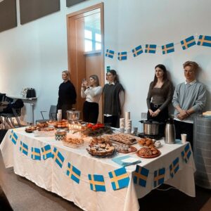 uczestnicy wydarzenia przy stole z potrawami