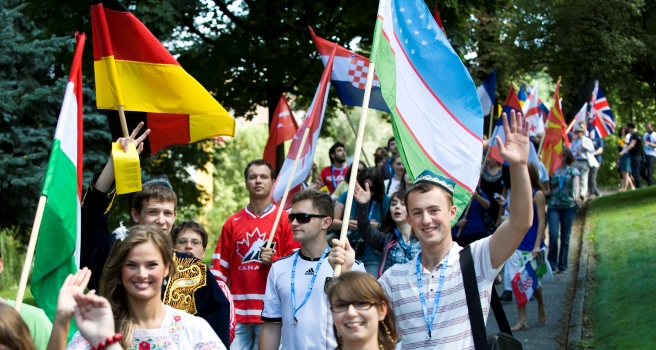 kolorowe zdjęcie: studenci z różnych krajów idący z flagami swoich państw