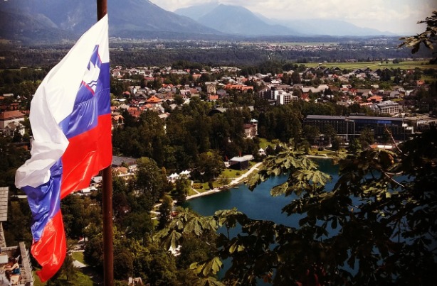 flaga Słowenii powiewająca na tle górskiego krajobrazu