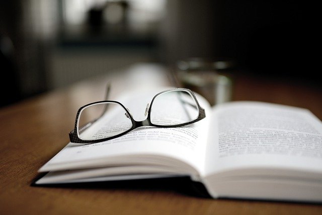okulary leżące na otwartej książce