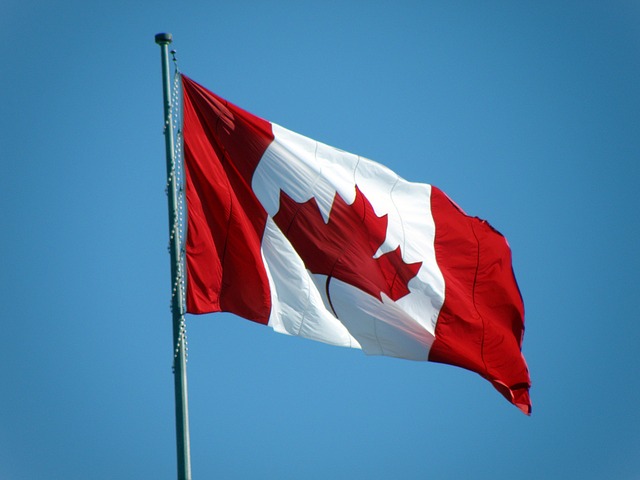 flaga Kanady powiewająca na tle niebieskiego nieba