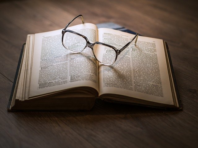 kolorowe zdjęcie przedstawiające okulary leżące na otwartej książce