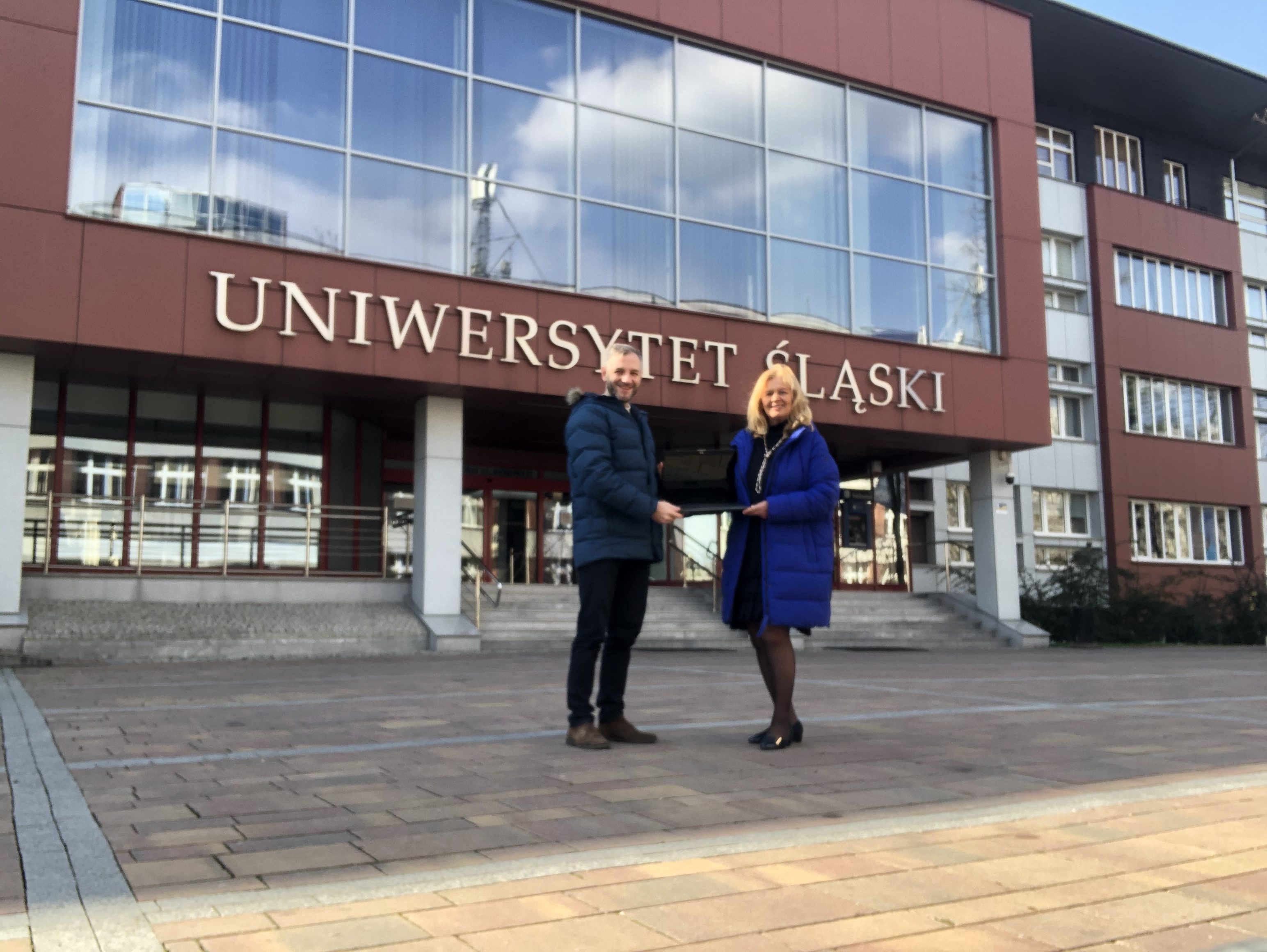 dwie osoby - kobieta i mężczyna, stojace przed budynkiem rektoratu Uniwersytetu Śląskiego w Katowicach