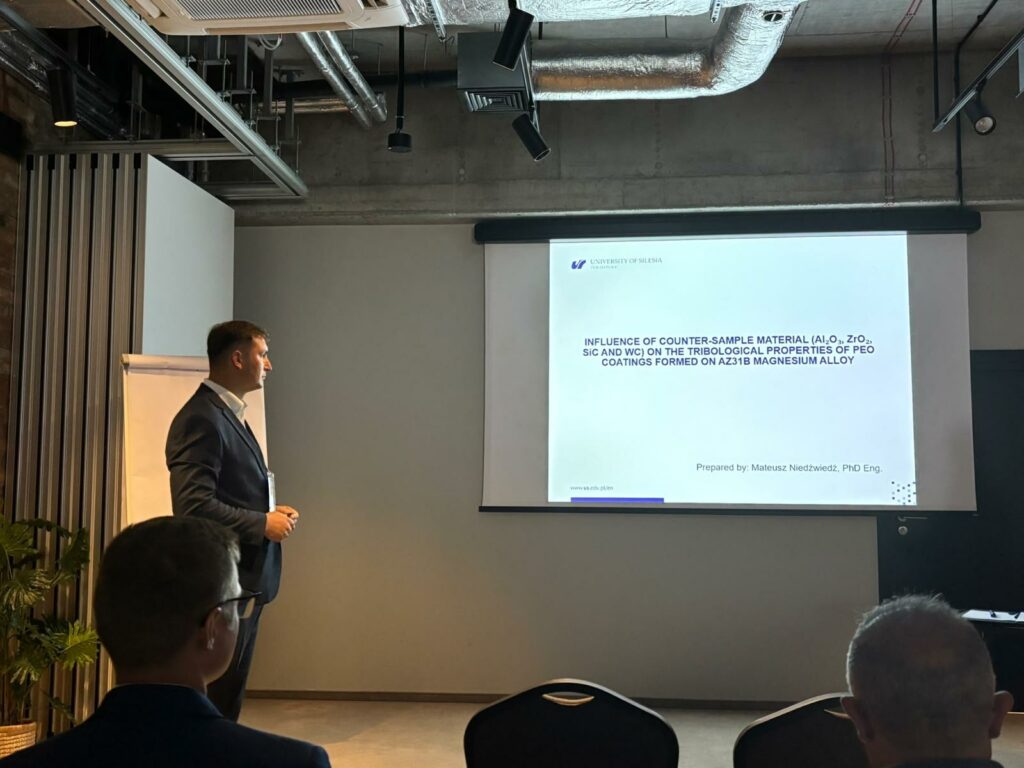 dr inż. Mateusz Niedźwiedź na 44th Polish Tribology Conference | Fot. Mężczyzna w sali konferencyjne patrzy na ekran