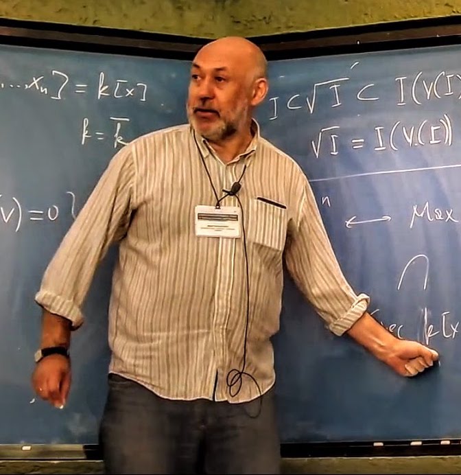 biały mężczyzna rozwiązuje zadania matematyczne przy tablicy