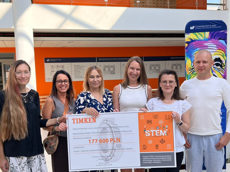 Grupa sześciu osób pozuje do zdjęcie trzymając imitację czeku na 177 tyś 600 zł