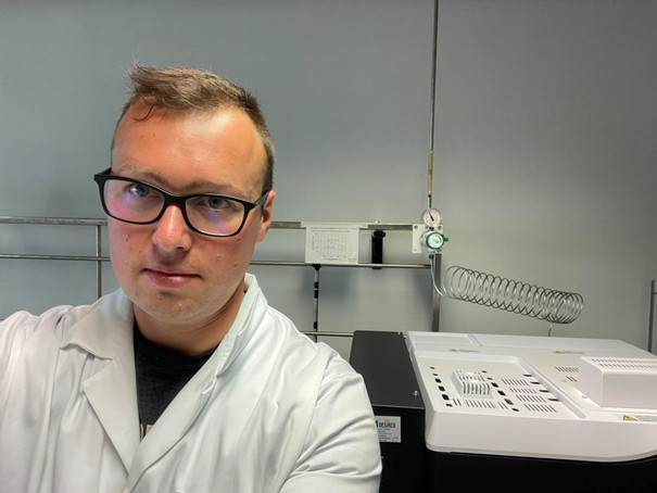 Tomasz Baran mężczyzna w białym fartuchu na tle aparatury