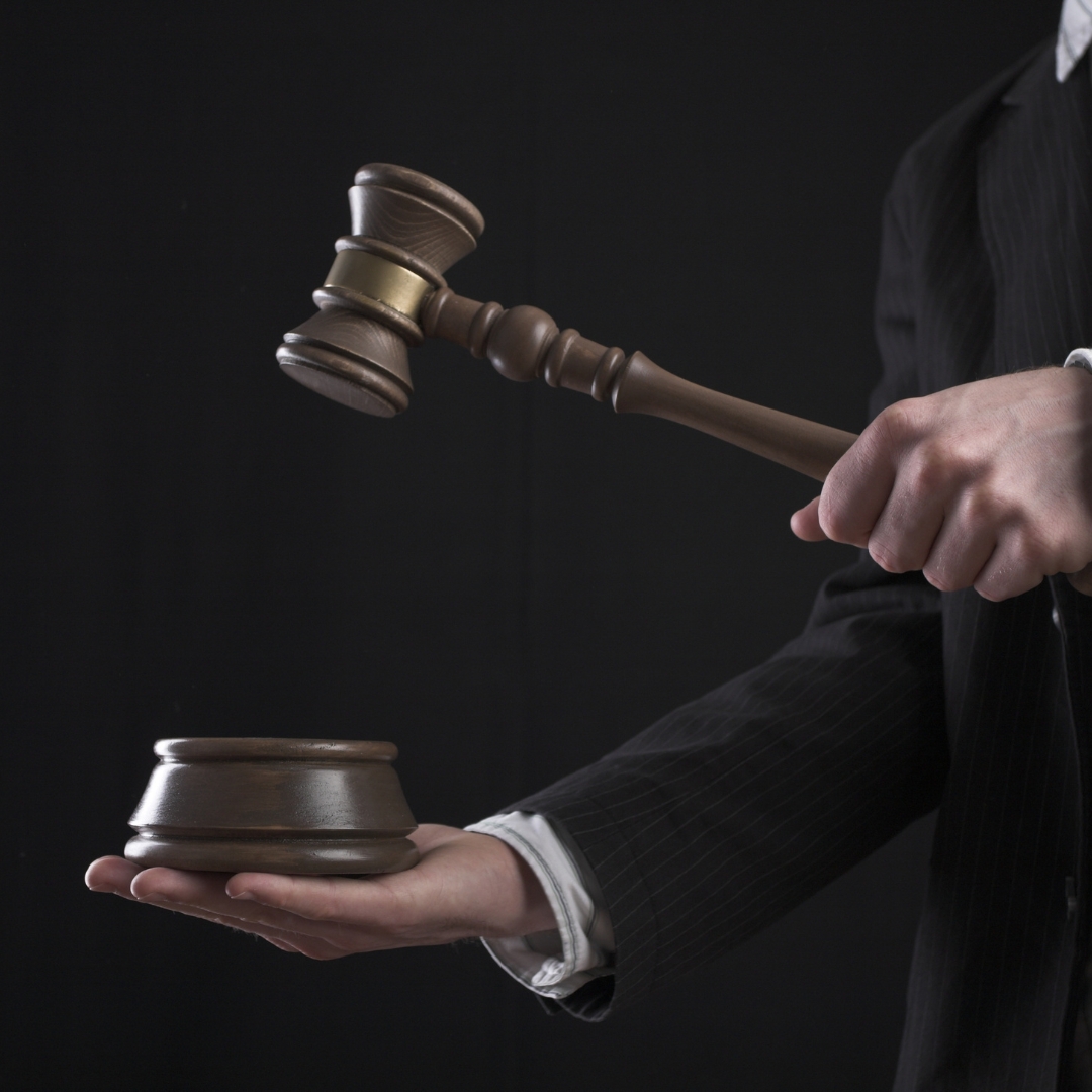 Młotek sędziowski trzymany w dłoni