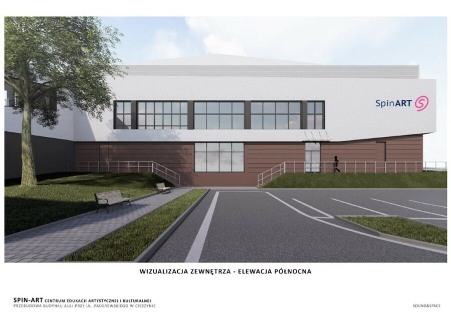 Wizualizacja budynku SpinART od północy. Obiekt ma prostą, geometryczną bryłę z dużymi przeszkleniami na piętrze oraz elewację w jasnym i brązowym kolorze, logo SpinART w prawym rogu. Przed budynkiem parking. Wizualizacja budynku SpinART od północy. Obiekt ma prostą, geometryczną bryłę z dużymi przeszkleniami na piętrze oraz elewację w jasnym i brązowym kolorze, logo SpinART w prawym rogu. Przed budynkiem parking.